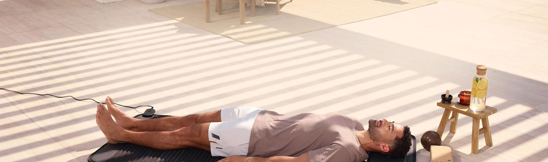 Man lying down, relaxing on PEMF Mat outside in the sun.